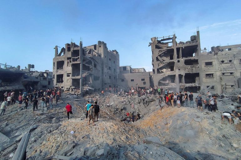 Palestinians search for casualties at the site of Israeli strikes on houses in Jabalia refugee camp in the northern Gaza Strip