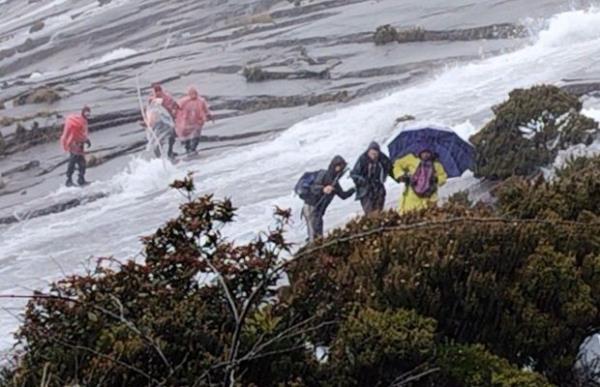 登山者从基纳巴卢山撤离，大雨将山顶变成了急流