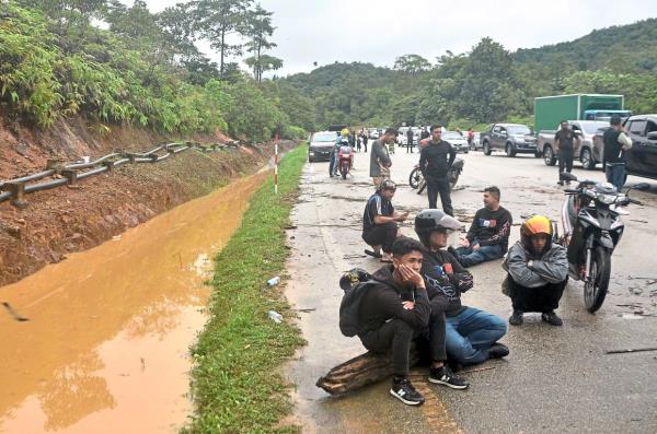 Nowher<em></em>e to go: Motorists sitting on the Lojing-Kuala Betis road after being stranded by floods in Gua Musang, Kelantan. — Bernama