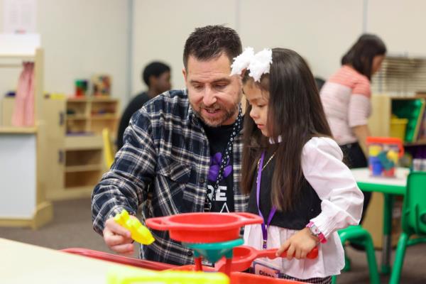 Mraz plays with a child at the Play 2 Learn programme. The students he teaches are part of this teaching profession programme.