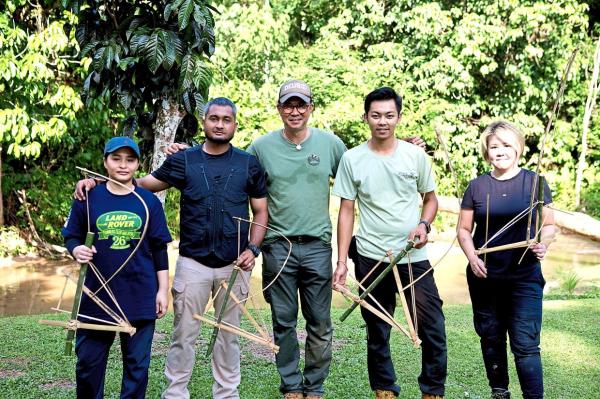 Shaik Reismann (centre) and participants of his parang skills workshop with their newly made small games trap made with bamboo and some rattan.