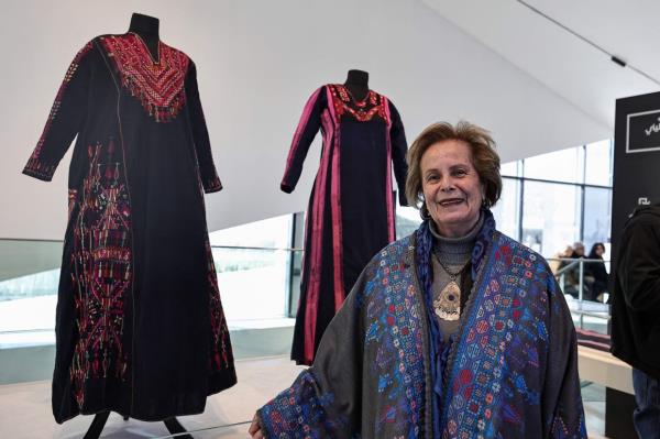 Palestinian artist Tania Nasser poses next to samples of the Gazan 'Thobe' or traditio<em></em>nal dress, displayed in the 'Ethnographic Collection Display: Women Of Gaza Exhibition' section, at the Palestinian Museum. Photo: AFP 