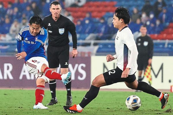 Yokohama’s Kota Watanabe (left) takes a shot at goal against Bangkok United during their last-16 match. — AFP