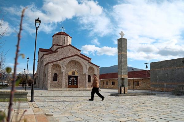 A man walking past the church in the centre in the village of Pustec. — AFP