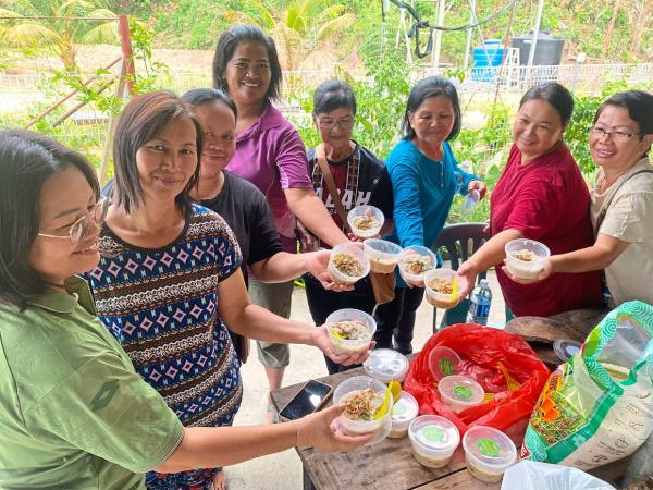 The women ready to taste bubur lambuk from another village.