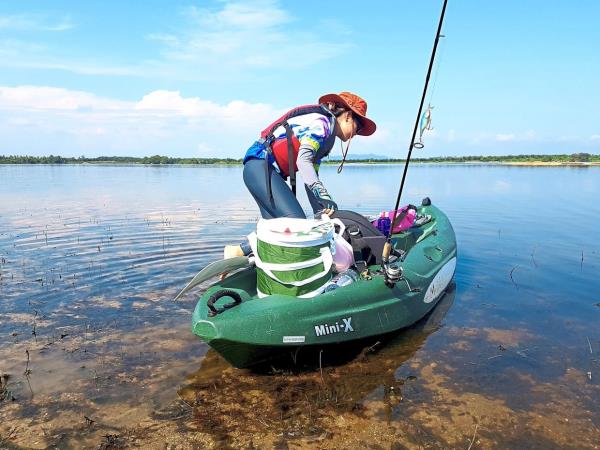 A kayaker a<em></em>bout to hop aboard her boat in clear waters on an ex-mining lake in Air Kuning, Perak.