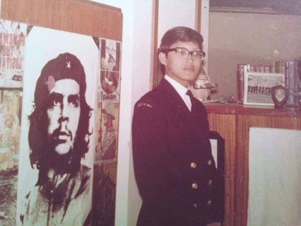 A clean shaven Chew, at 21, in his room at HMS Collingwood, RN School of Weapons Electrical Engineering, Portsmouth, UK standing by a poster of his hero at the time, Che Guveara.