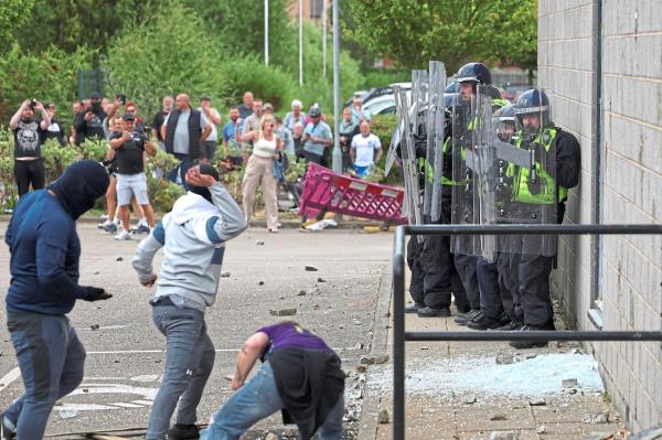 Big protest: Demo<em></em>nstrators throwing things at police officers during an anti-immigration protest in Rotherham, Britain. — Reuters