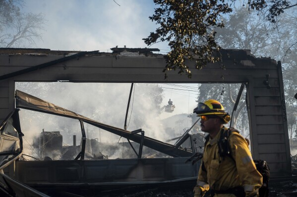 A firefighter passes a home destroyed by the Boyles Fire in Clearlake, Calif., on Sunday, Sept. 8, 2024. (AP Photo/Noah Berger)