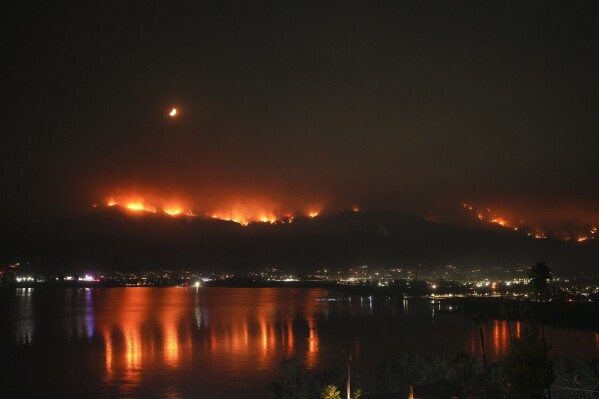 The Airport Fire is reflected on Lake Elsinore, Tuesday, Sept. 10, 2024, in Lake Elsinore, Calif. (AP Photo/Eric Thayer)