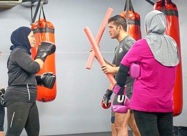 Chee (centre) is a certified perso<em></em>nal trainer in MMA. Photo: Instagram/Dan Chee