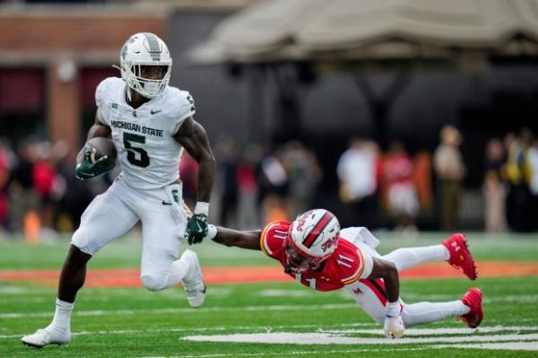 Michigan State running back Nate Carter (5) advances past Maryland defensive back Kevyn Humes (11) during the first half of an NCAA football game, Saturday, Sept. 7, 2024, in College Park, Md. (AP Photo/Stephanie Scarbrough)